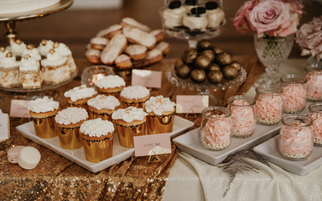 Babeczki, ciasteczka i różowe desery na eleganckim słodkim stole