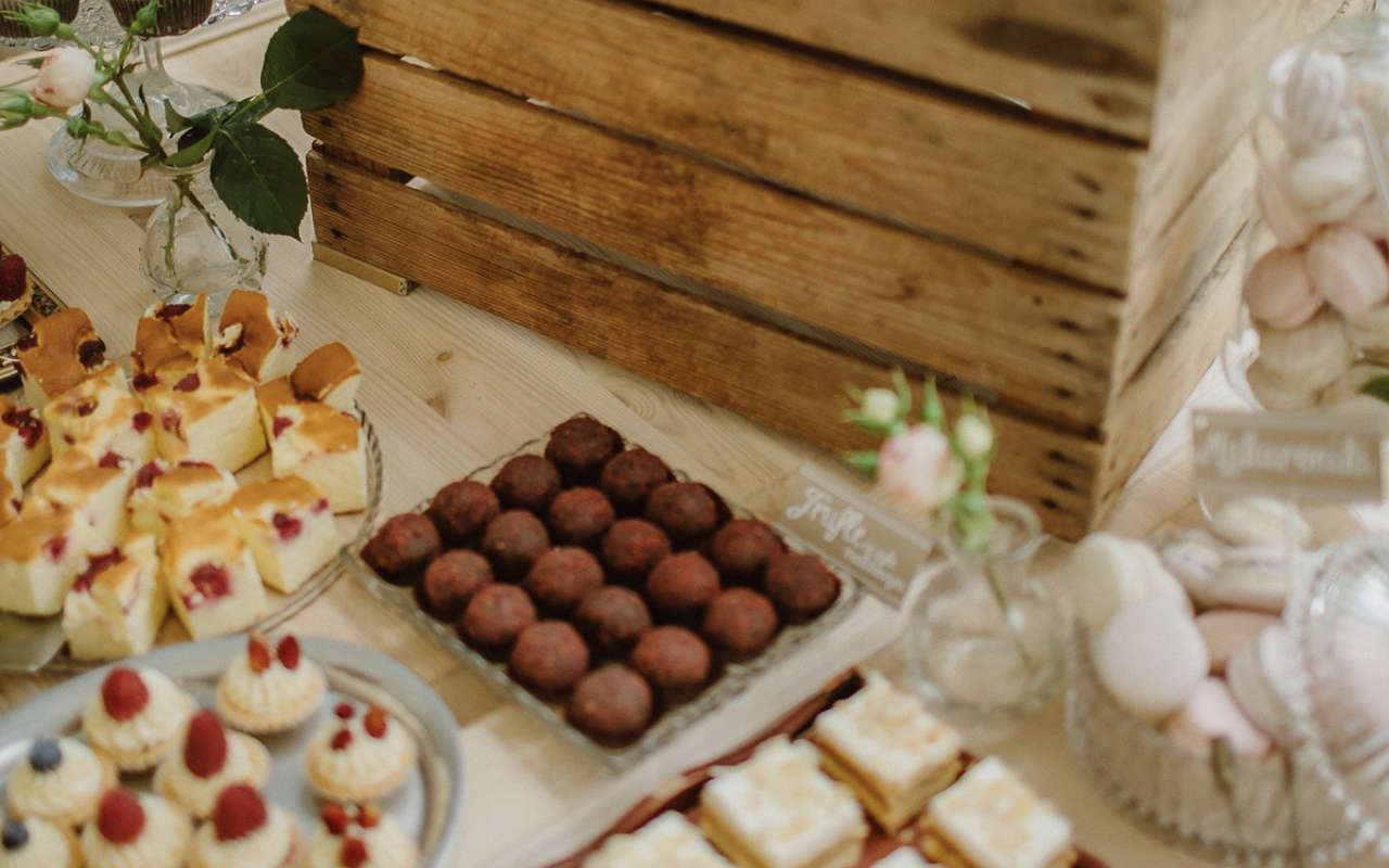 Trufle czekoladowe, ciasta i makaroniki w rustykalnej aranżacji słodkiego stołu